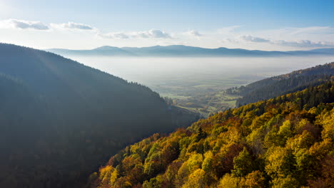 aerial hyperlapse flying over mountain, valley covered in vibrant autumn forest