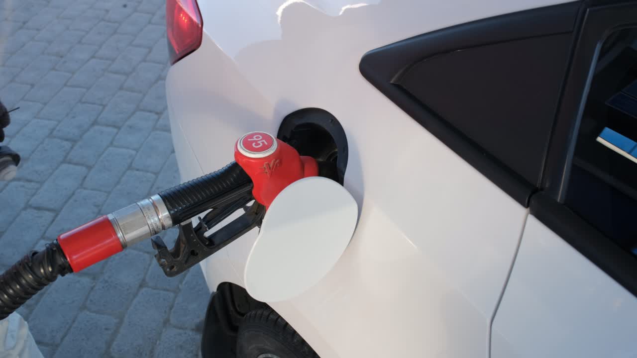 연료 를 채우는 여자 가 가솔린 을 채우고 있다