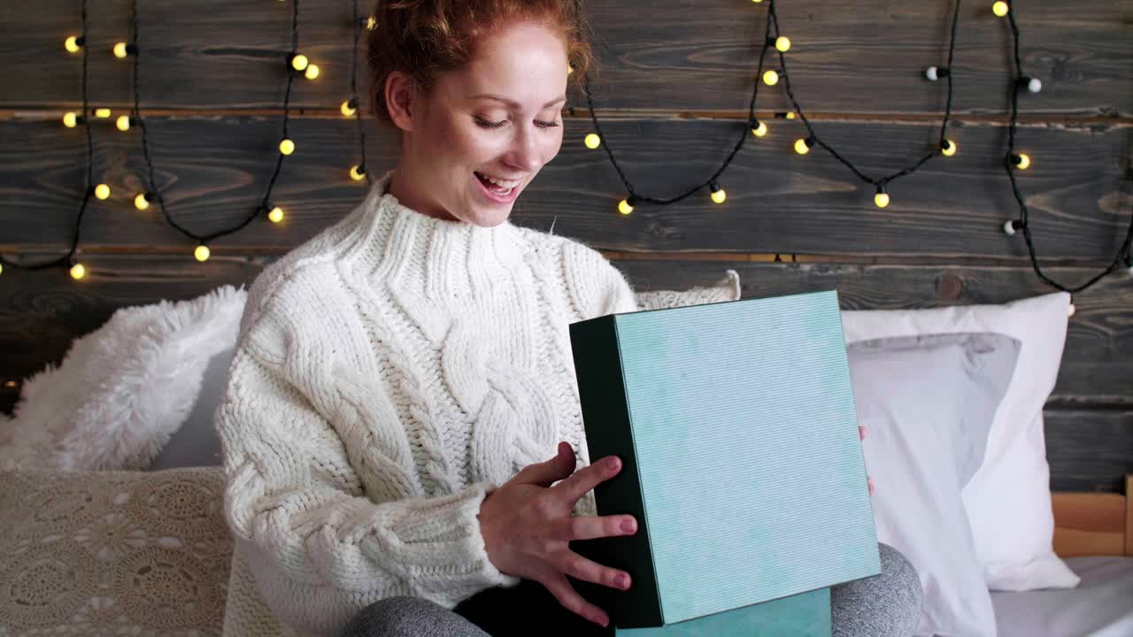 mujer sorprendida abriendo regalos de navidad