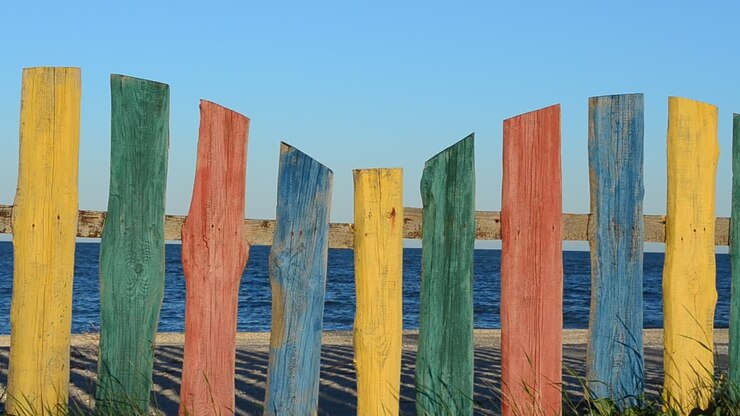 Cerca multicolorida na praia. Cerca e céu, verão.