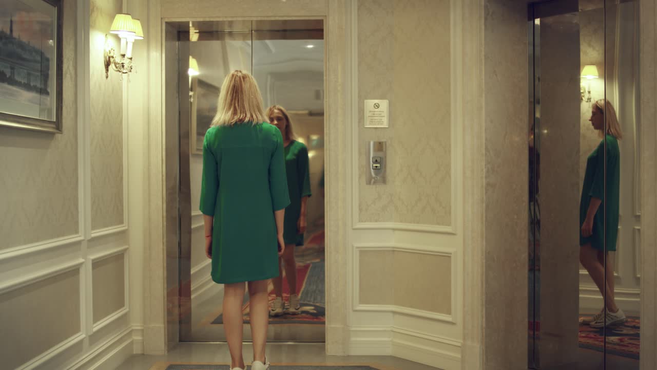 joven presionando el botón para llamar al ascensor y esperando en el apartamento