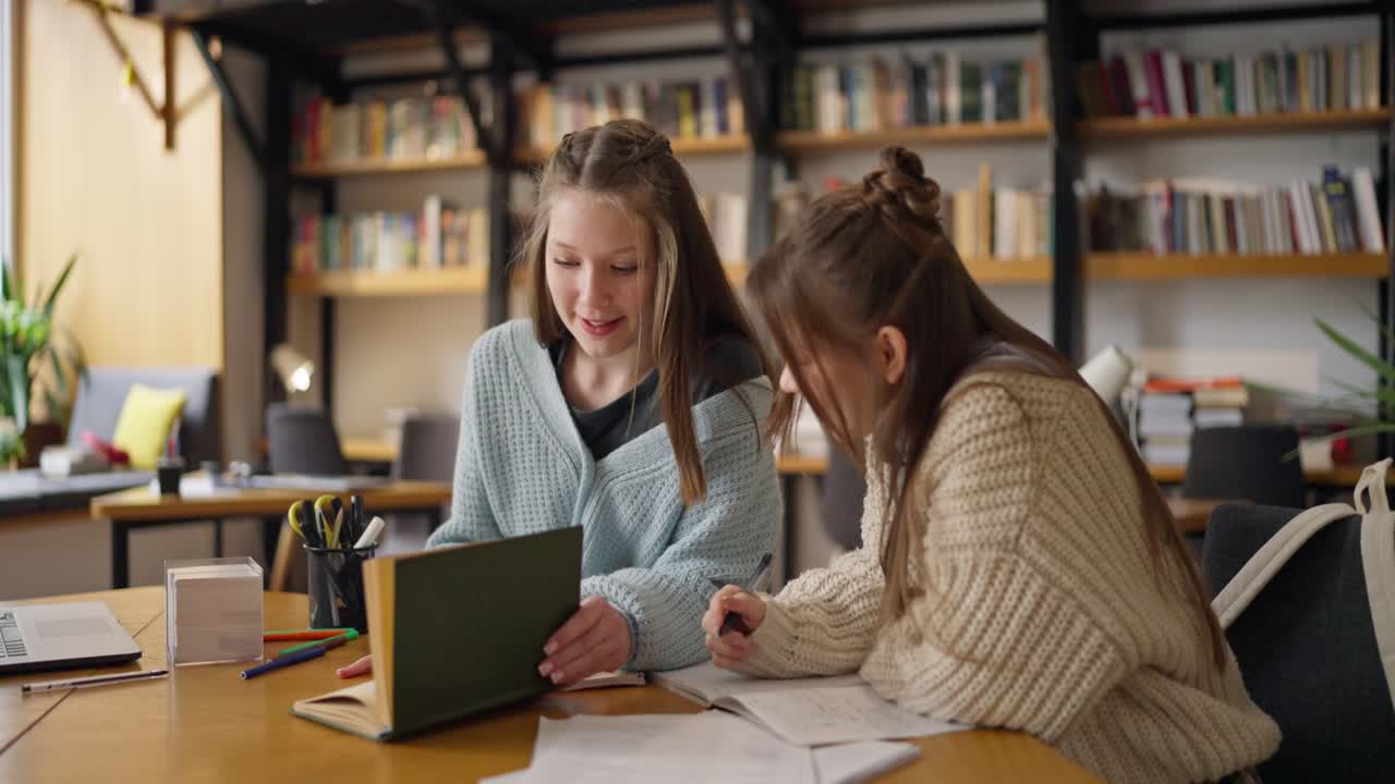 Two Teen Girls Studying Together in a Library