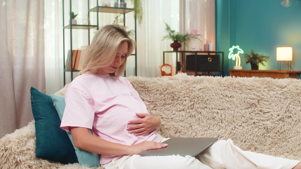 Pregnant woman closes laptop after client rejection in freelance work showing disappointed posture