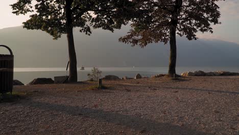 lege oever van het gardameer bij zonsopgang, geweldig panorama, mistige berg aan de horizon