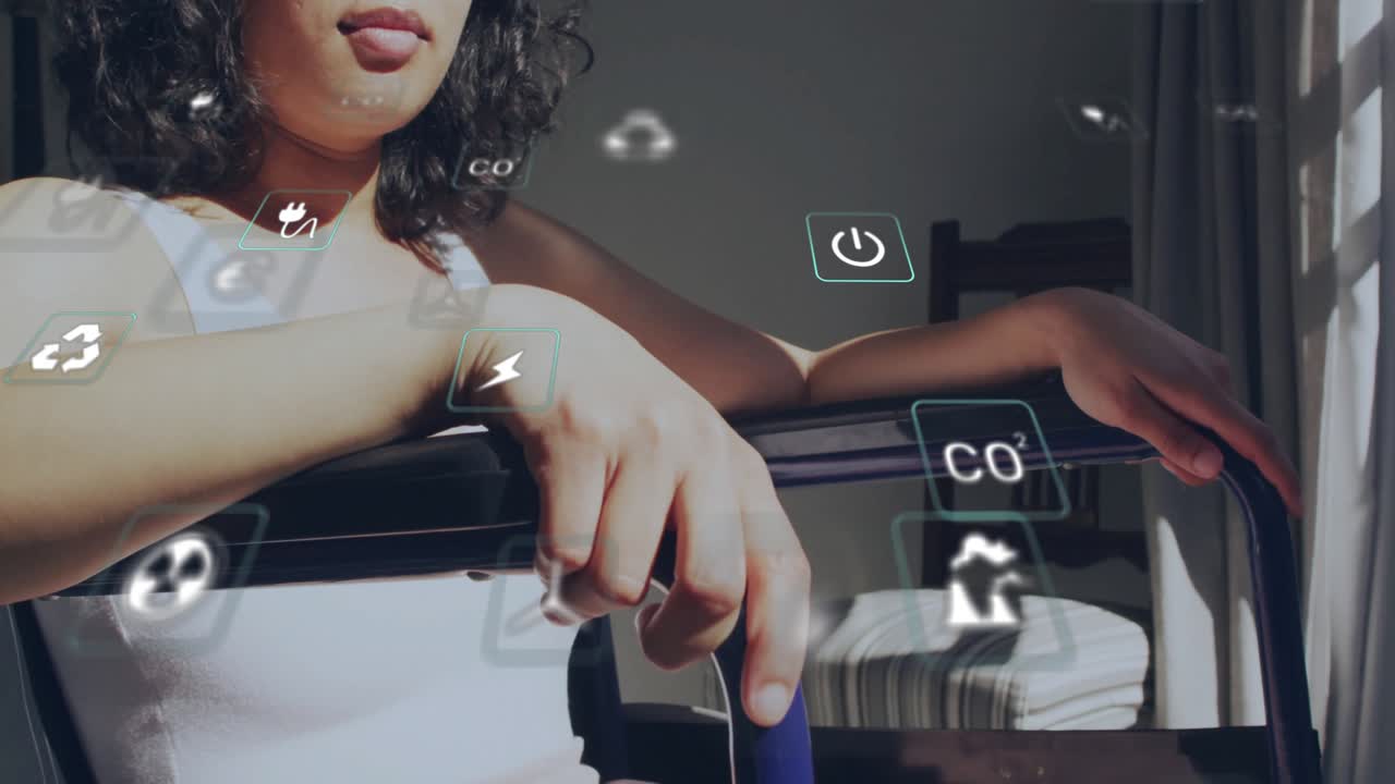 Animation of energy and ecology icons over woman in wheelchair in sun