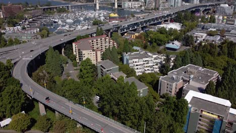 aerial dolly roll over granville island bridge park residential community on a hot hazy summer afternoon with minimul people out during covid-19 pandemic lockdown false creek yachts docked 1-4
