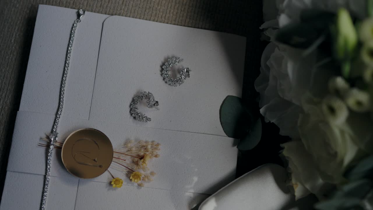 accesorios de boda, incluidos pendientes, pulsera, ramo y un sobre, que muestran los detalles de la boda