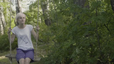 mujer balanceándose en un parque forestal