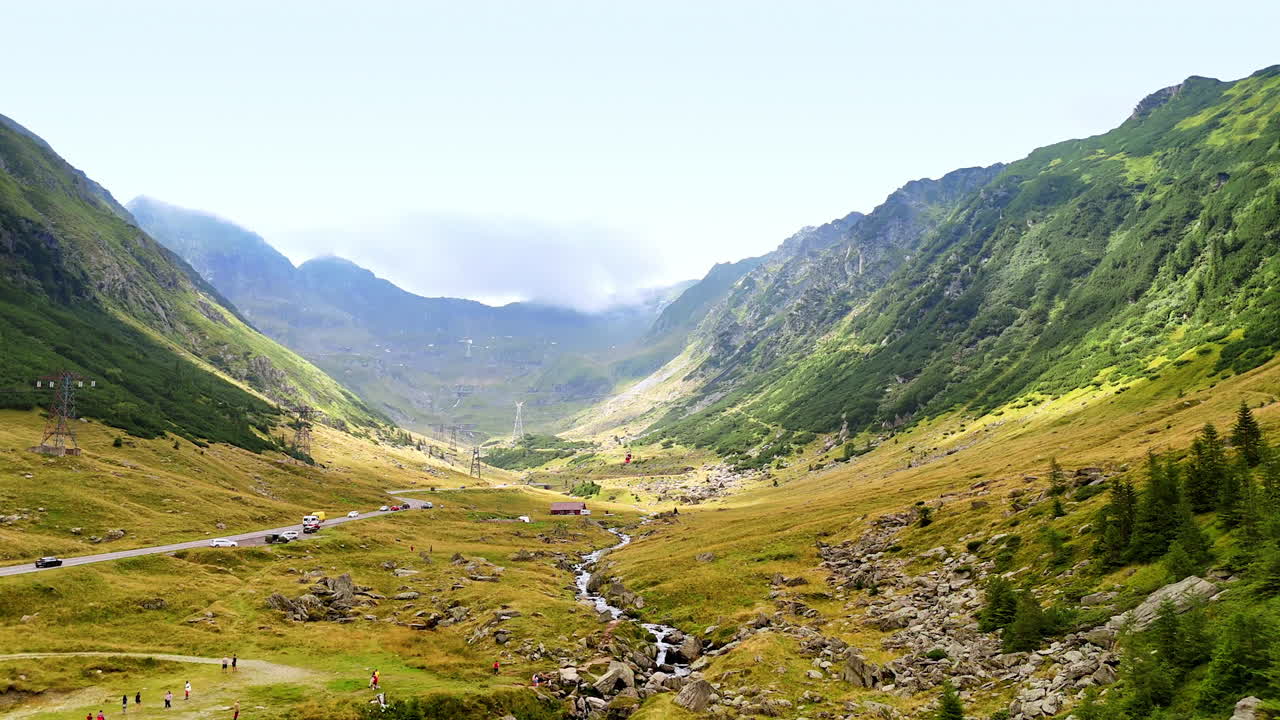 Groene vallei en beek vlak bij de Transfagarasan-weg. Luchtfoto van de Transfagarasan-vallei met een bergbeek en omliggende heuvels