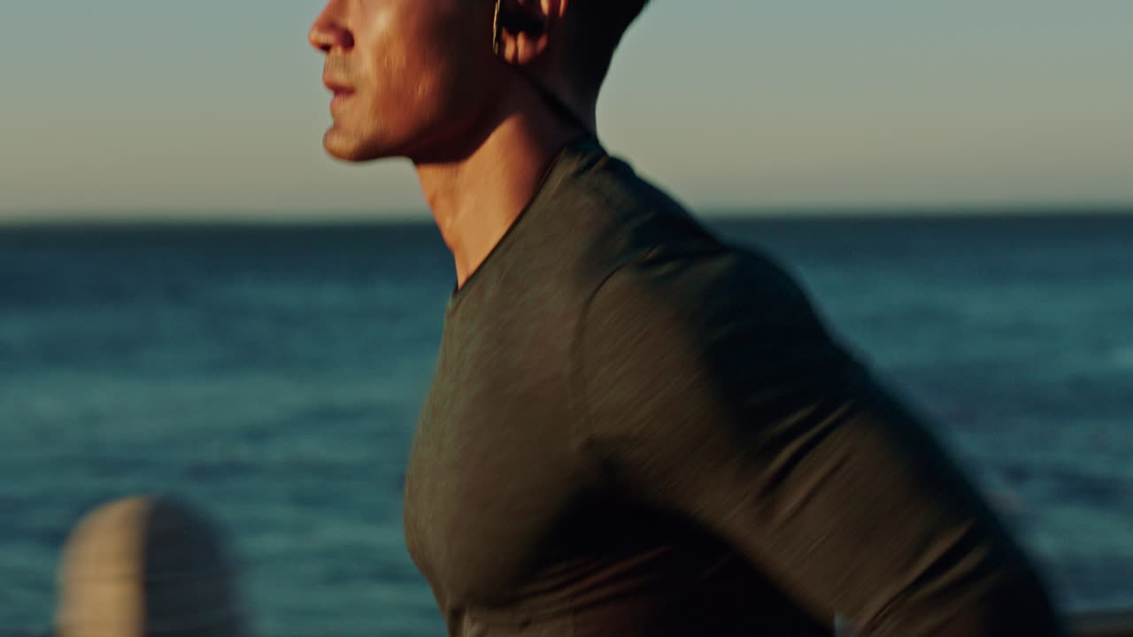 Fitness, running and man with earphones by beach