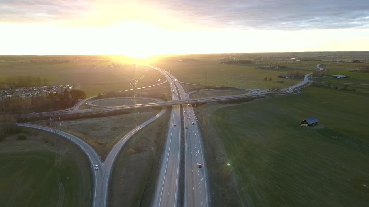 Vista aerea di uno svincolo autostradale con traffico veicolare in movimento.