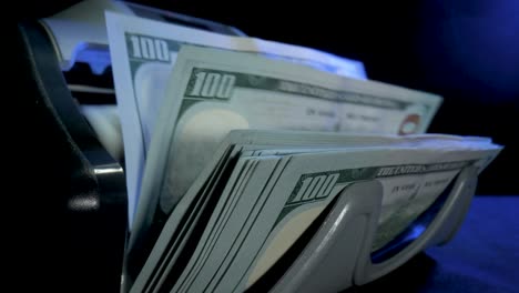 counting hundred dollar bills in a bill counter