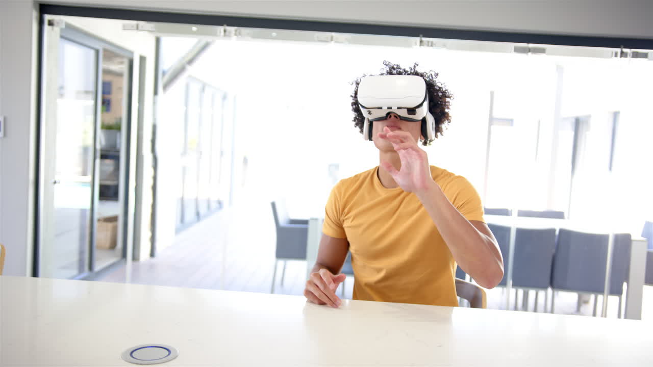 un joven biracial está usando gafas de realidad virtual en casa en la cocina, fondo blanco