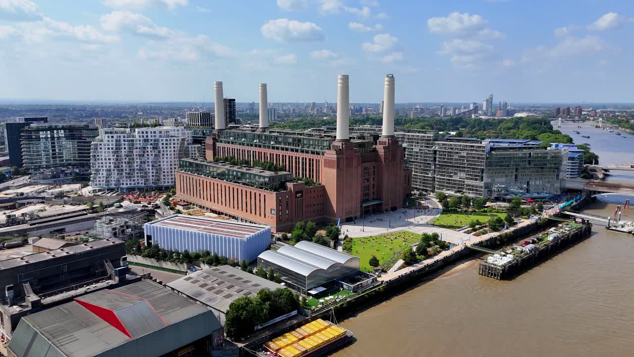 Sweeping aerial view over Battersea, London, capturing the iconic Battersea Power Station, modern riverside developments, and the River Thames under golden hour light