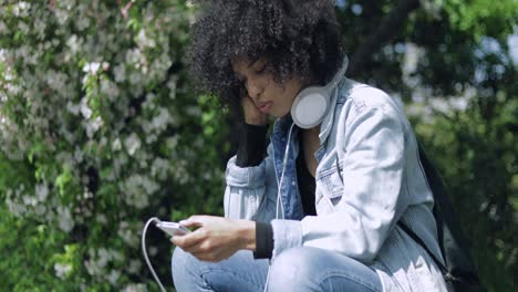 Mujer-Con-Grandes-Auriculares-En-El-Parque