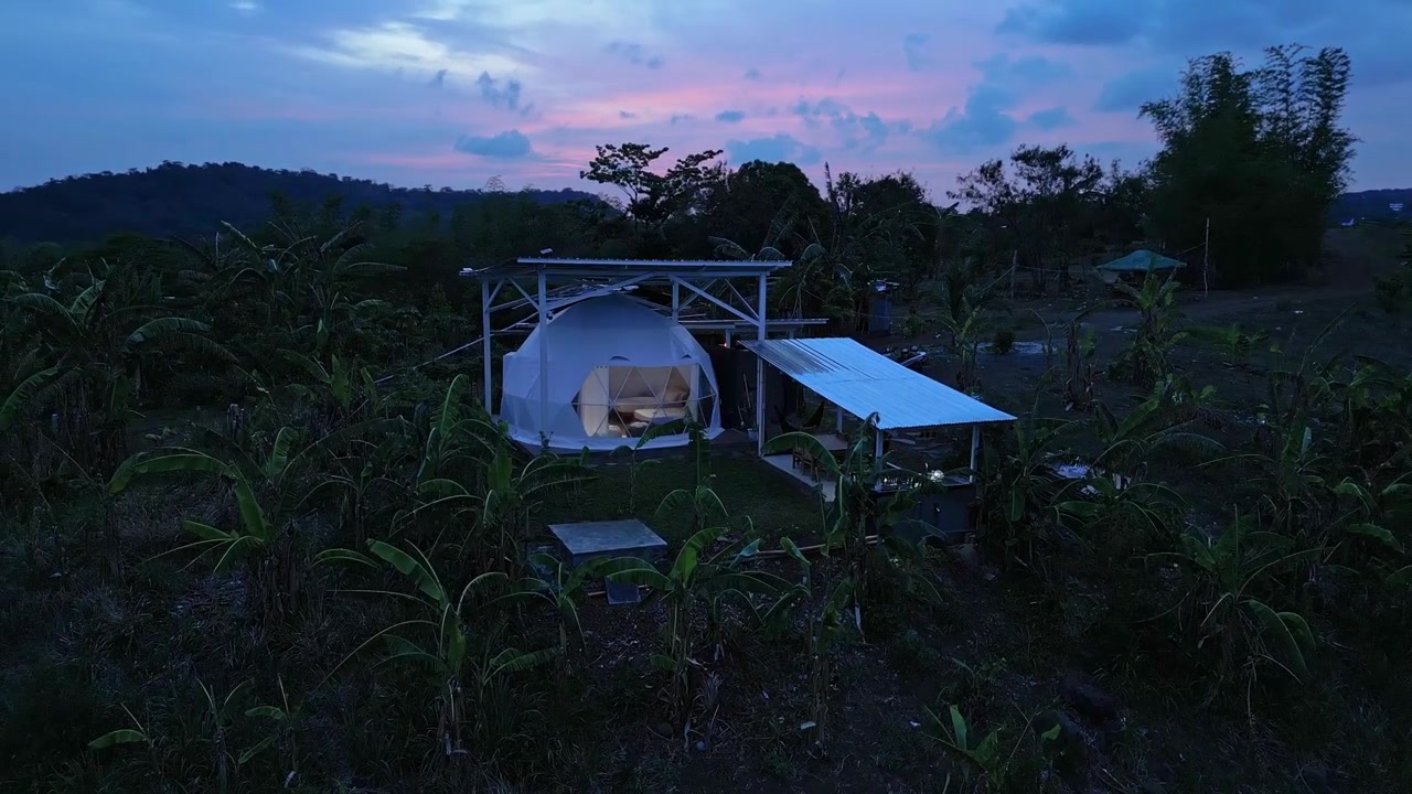 Luftfoto i den blå time af et kuppel-retreat i Tanay, Rizal, med aftenlys, bjergsilhuetter og det naturlige landskab nær Pililla-floden.