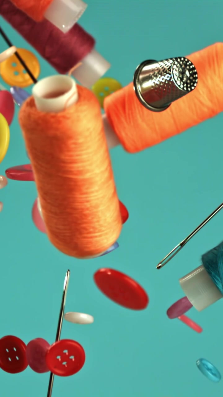 Colorful Sewing Supplies and Notions Floating Against a Teal Background