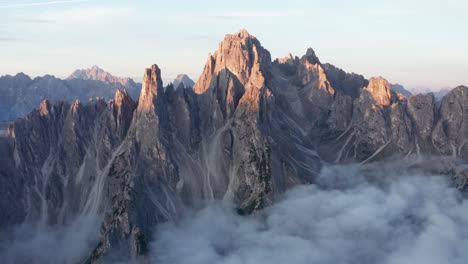 die ersten strahlen des sonnenaufgangs fangen die zerklüfteten gipfel der cadini di misurina, der dolomiten ein