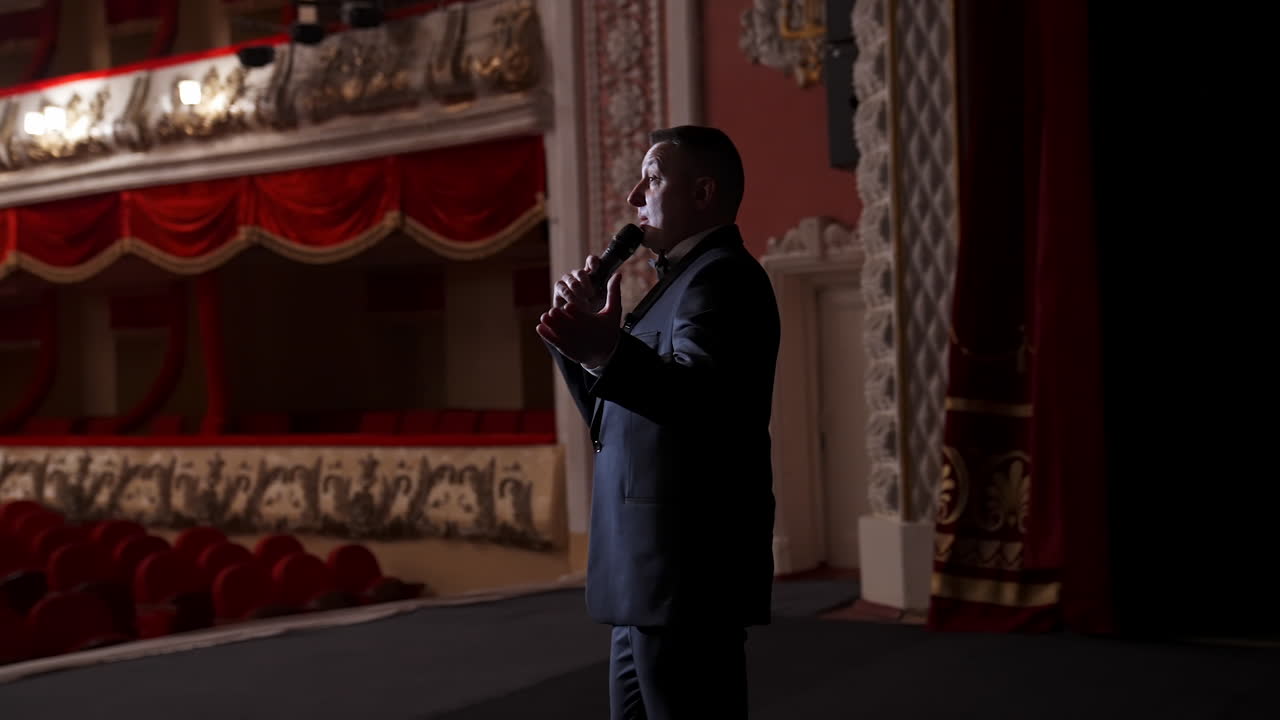 Presenter with microphone speaks with the empty auditorium. Concept of quarantine,cancellation of mass events to prevent spread of coronavirus infection.