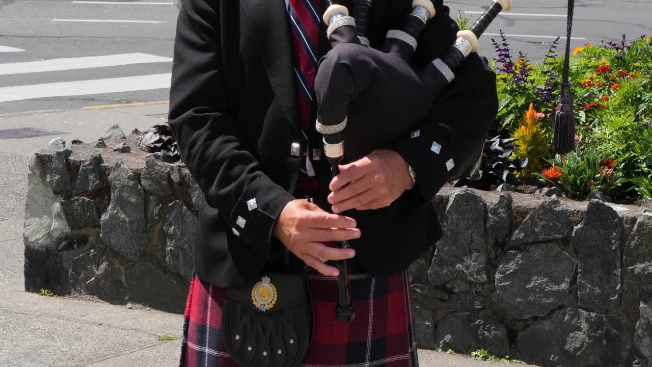 Bagpiper playing around the Parliament Buildings in the summertime in Victoria, Canada, British Columbia.