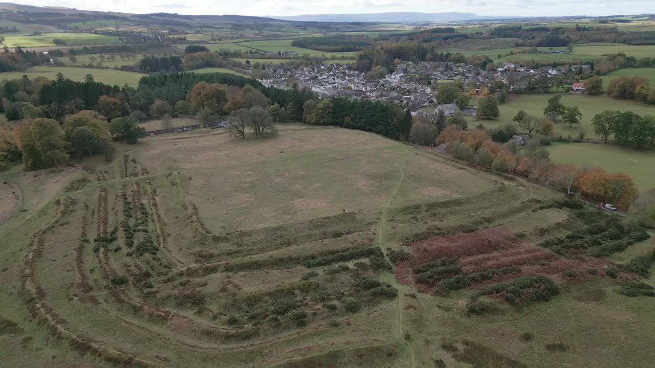 Beautiful Aerial view of Ardoch Roman Fort and the village of Braco in Scotland. Drone flying forward