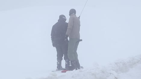 Skier-and-Snowboarder-on-a-T-Bar-lift-in-a-snowy-mountain-ski-resort