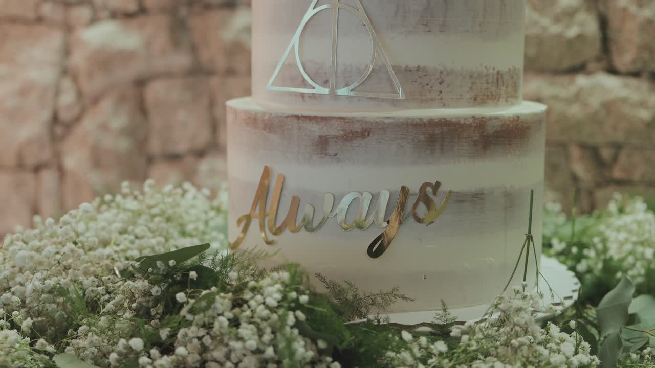 tarta nupcial de dos pisos con decoración floral y adorno geométrico