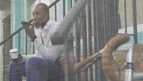 animation of statistics recording over african american man talking on smartphone sitting on steps