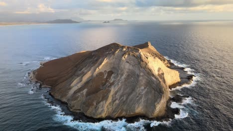 slow and steady drone footage of manana island in hawaii with beautiful waves crashing against the island