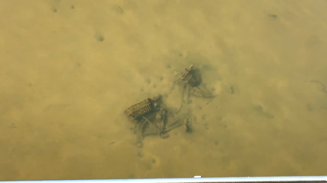 Submerged, rusted bike discarded in river water