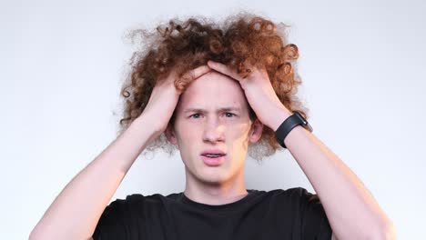 closeup of face of worried redhaired curly guy looking at camera closeup of face of worried redhaired curly guy looking at camera headache poblem fail trouble