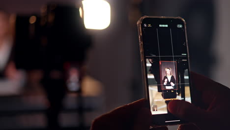 switched on camera on the phone. video of a woman talking at backdrop is taken on the smartphone. close up.