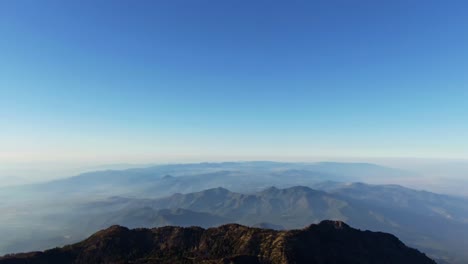 Wide aerial pan right from Nevado de Colima summit over valleys in Colima and Jalisco