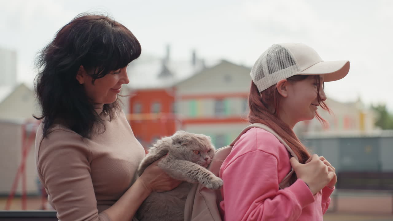 Caucasian Guardian Secures Rabbit In Backpack As Student Prepares To Leave, Final Adjustments To Straps And Buckle, Warm Sendoff With Gentle Support And Morning Light Over Urban Playground