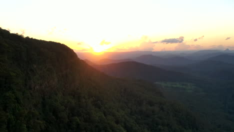 Toma-Aérea-De-Lapso-De-Tiempo-De-Una-Puesta-De-Sol-Cerca-De-Una-Gran-Montaña-En-El-Parque-Nacional-Border-Ranges,-Nueva-Gales-Del-Sur-En-Australia