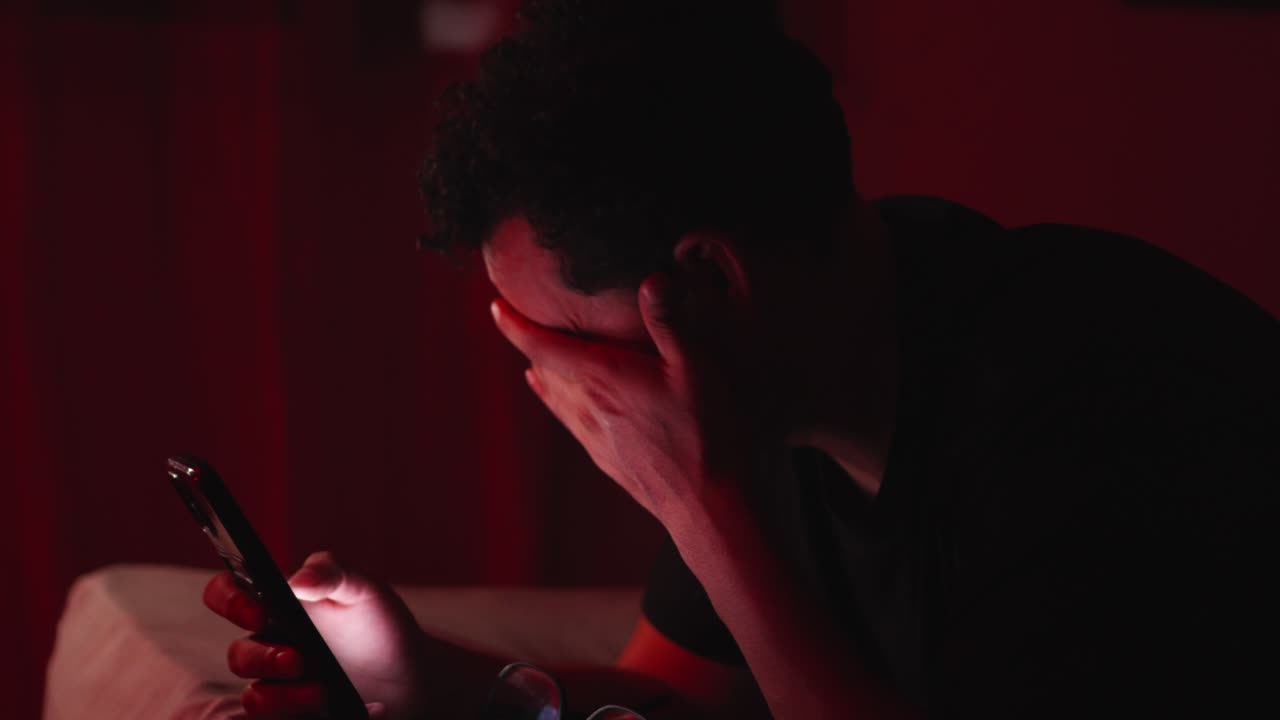 Uomo ispanico adulto con dipendenza da telefono cellulare e problemi di vista.
