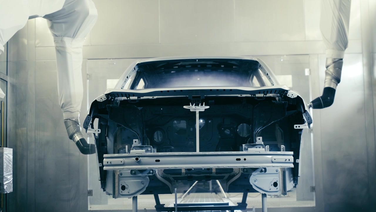 Robotic Arms Spray Painting a Vehicle Body at a Car Manufacturing Factory. 4K .3