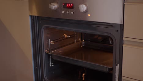 a person is putting a baking dish into a preheated oven.