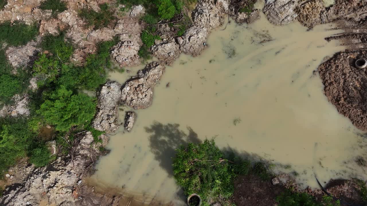 Aerial view of a construction site with muddy puddle