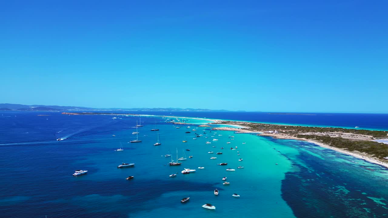 Hyperlapse con rampa di velocità e ripresa aerea accelerata di molte barche da diporto ancorate nelle acque turchesi e cristalline di Formentera, isola delle Baleari. Panoramica aerea magica con drone, con vista dall'alto, volo inverso e panorama.