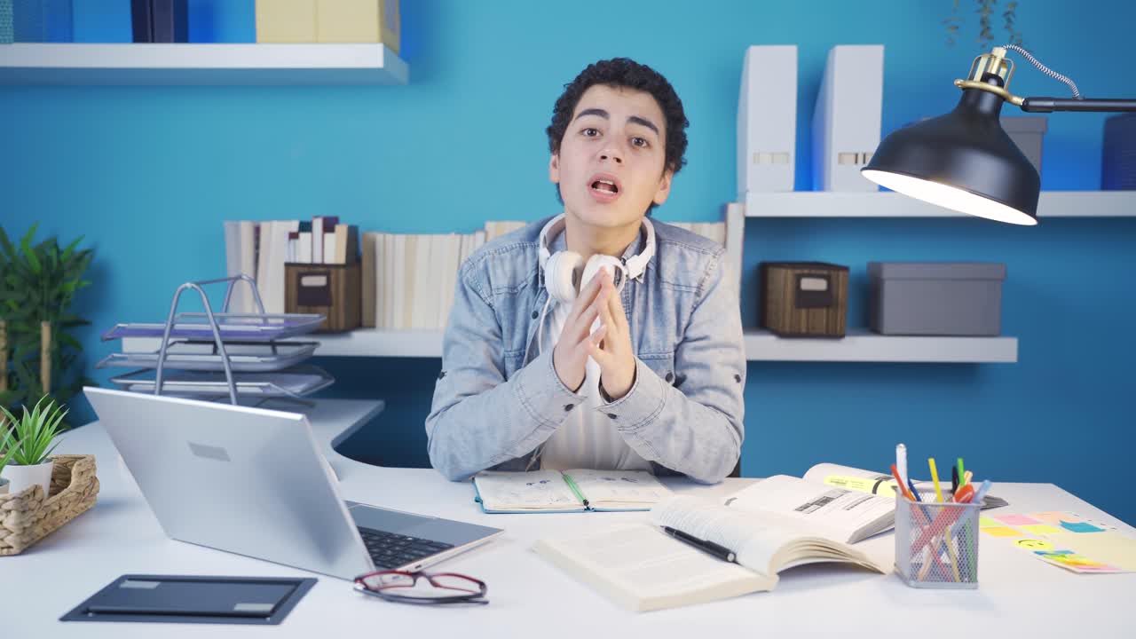 카메라를 쳐다보고 뉴스를 기다리는 불행한 남학생은 그가 기대하는 뉴스가 오지 않을 때 우울해집니다.