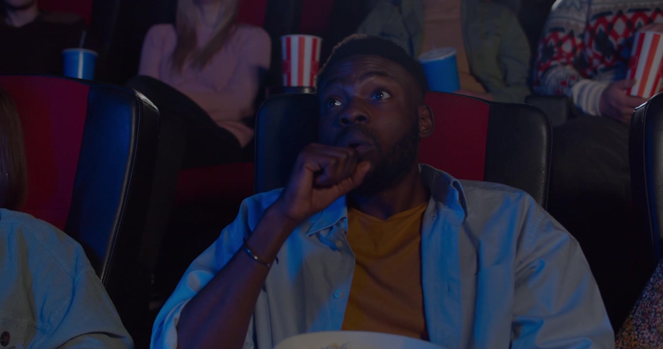 Ung mand ser en intens film i en biograf