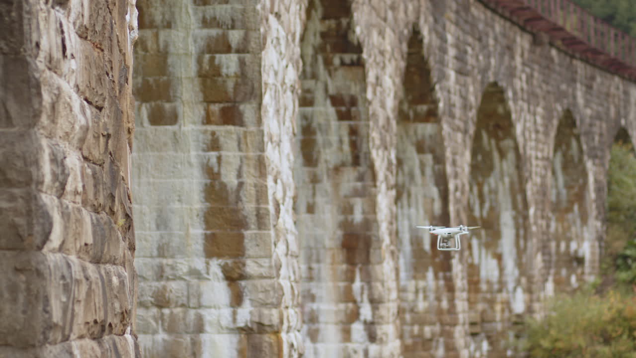dron volando sobre un viejo puente de arco de piedra