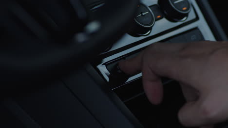 close-up of toggling on and off the mode button inside a car