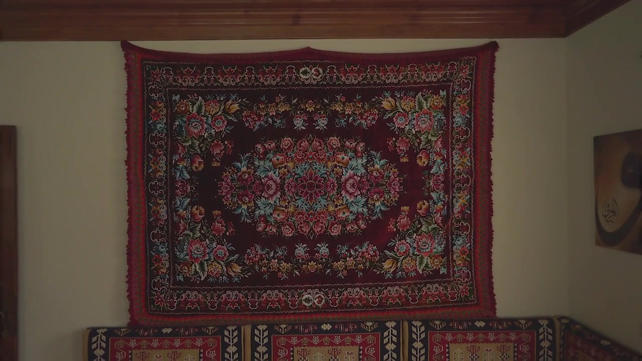 Rahat bir oturma odasında duvarda asılı geleneksel çiçekli goblen
