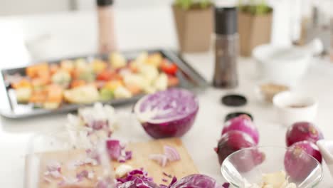 Close-up-of-vegatables-and-glass-with-red-wine-in-kitchen,-slow-motion