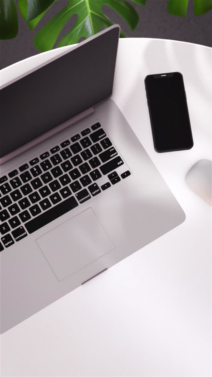 Area di lavoro moderna con laptop, smartphone e mouse su scrivania bianca