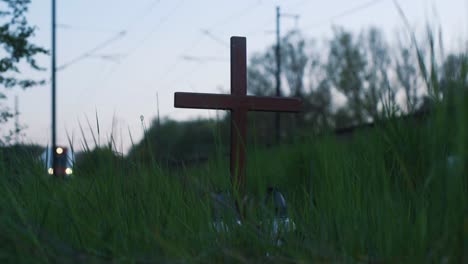 cross near railway track with train arriving