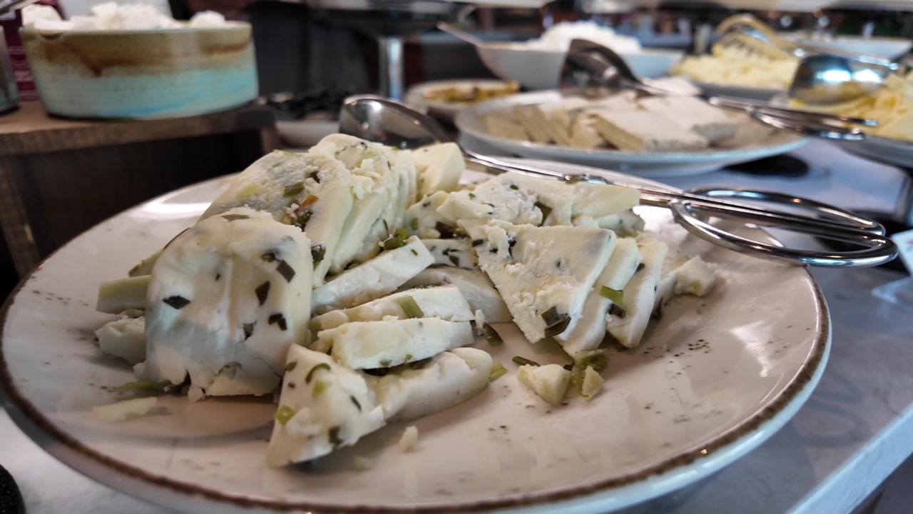Primo piano di formaggio alle erbe a fette su un vassoio da buffet