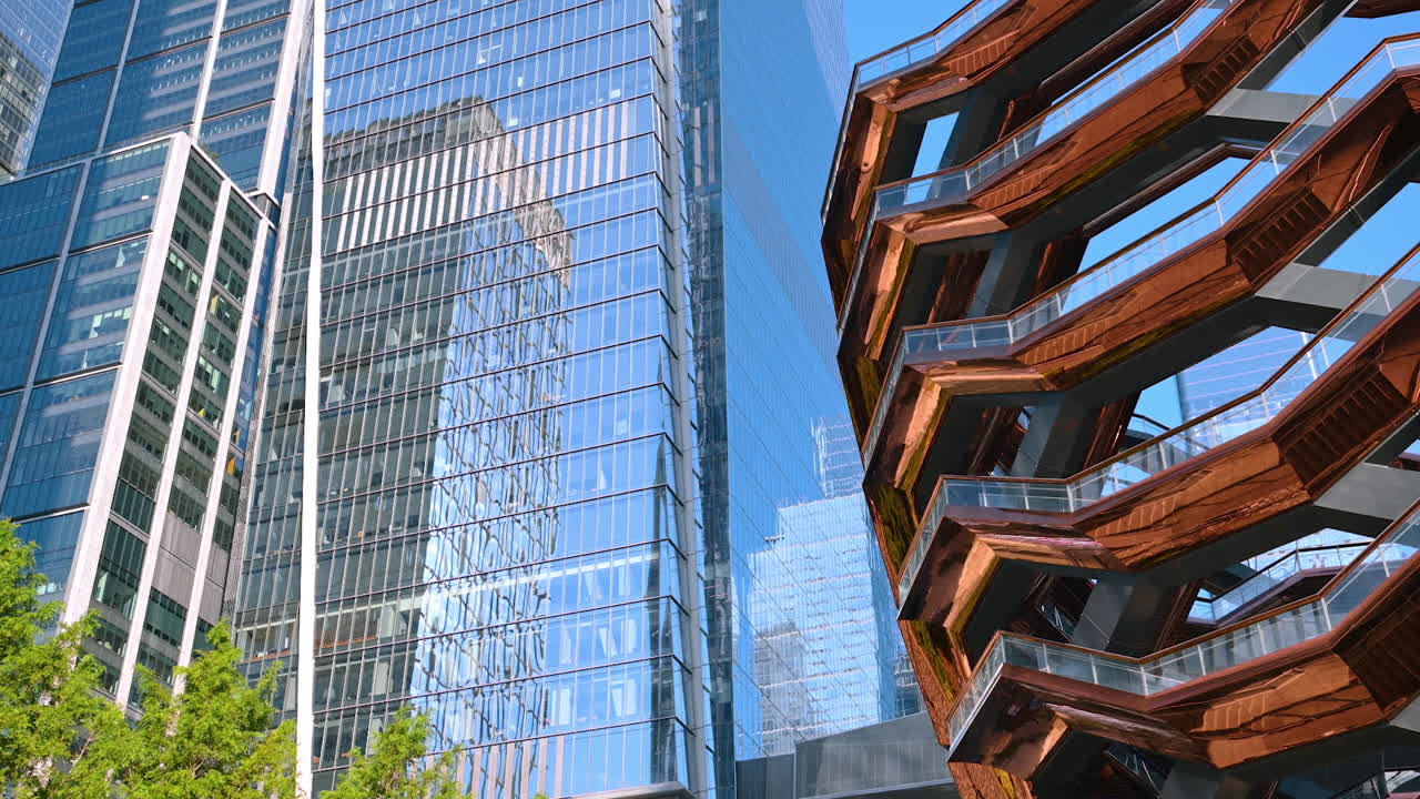 New York, USA, 5 August 2025: The Vessel Structure surrounded by the glass high-rises. Low angle view at the architecture of modern New York, USA